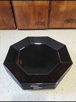 Stack of six black octagonal glass plates