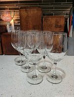 Front view of all six clear wine glasses standing on countertop