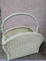 Full view of white wicker magazine basket