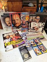 Group shot of all magazines, coin pack, trading cards and photo print