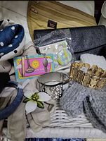 Close-up of assorted accessories showing bags, scarf, gloves, belts, jewellery and packaged pins