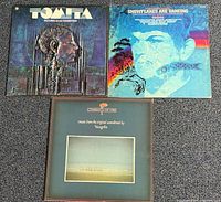 Front covers of three vinyl albums laid out on carpet