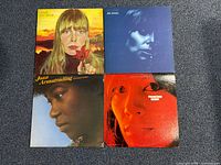 Group shot of four album covers laid out on carpet