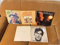 Group of five LP sleeves displayed on couch