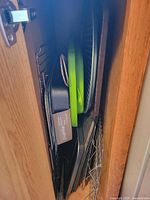 Stack of assorted bakeware, racks, boards in cabinet
