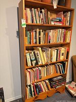 Front view of tall wood bookcase with books (contents not included)
