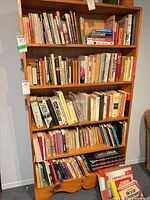 Full view of five-shelf wooden bookcase filled with books