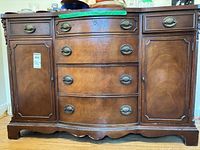 Front view of wood buffet showing drawers, cupboards, hardware