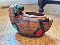 Side view showing carved figure, paint colors, overall form