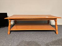Front view of rectangular wood coffee table with lower shelf