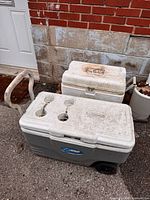 Front view of Coleman wheeled cooler and Igloo chest cooler showing overall condition