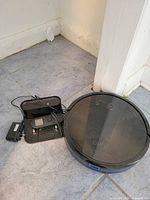 Top view of RoboVac 11S with dock, remote on dock and power adapter