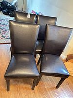 Front view of four faux leather dining chairs