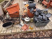 Wide view of assorted planters, solar lights, lantern, wire basket, wall decor