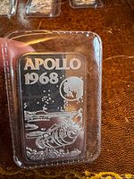 Obverse of silver bar in plastic showing Apollo 1968 design