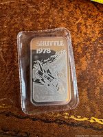 Front of Johnson Matthey Shuttle 1978 silver bar in plastic