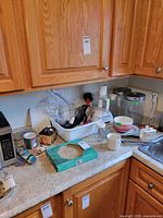 Overview of countertop showing blender, utensils in tub, mugs, bowls, mold box