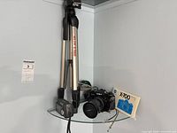 Shelf view showing SLIK tripod, Kodak camera and Minolta X-700 with manual