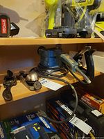 Shelf showing electric speed sander, hand plane, spokeshave, power cords