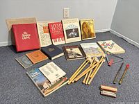 Overview of all items on floor: mallets, whistles, triangle, harmonicas and music books