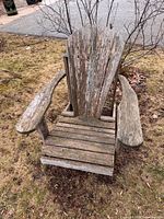 Front view of weathered wooden Muskoka chair on lawn