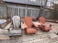 Three wooden Muskoka chairs on deck