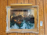 Framed Joseph Purcell oil painting with lighting above