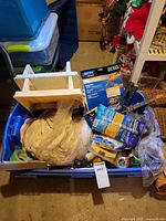 Overall contents in blue bin showing gloves, tape, trays, rollers, sanding items