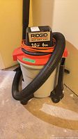 Full view of RIDGID wet/dry vacuum showing canister, lid, hose and cord