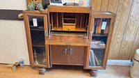 Front view of walnut secretary desk with drop-front open and side glass doors