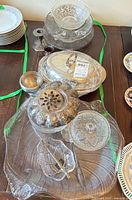 Group of silver-plated and glass serving pieces on table