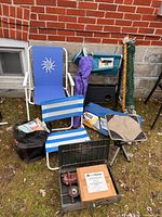 Group shot of all camping items including chairs, tent bag, hammock bag, cookstove in crate