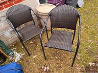 Two brown resin wicker outdoor chairs side by side