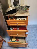Drawer unit showing open drawers with flatware tray, utensils and Tupperware