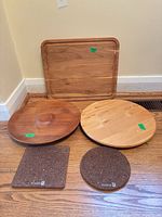 Group shot of all five items: rectangular board, two wooden turntables, square and round cork trivets