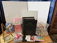 Full lot view showing canvases, easel, glue guns, stamps, book, embellishments