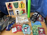 Overview showing wooden skill board, toy vehicles, dart blaster, lacing cards, wooden pieces, books