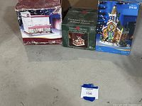 Three boxed porcelain lighted village buildings grouped together