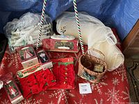 assorted décor on red snowflake mat: candy-cane stakes, window candles, mesh roll, bow packs, wicker basket