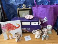 Overview of lot showing metal van, canvas art, planters, lotus holder, tote bags, cups
