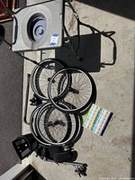 Commode chair, wheels, pill organizer grouped on floor