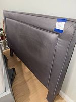 Front side of gray upholstered headboard