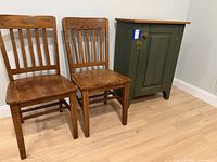 cabinet closed alongside two dining chairs