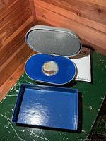 Coin in open presentation case with outer box visible