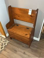 Front view of solid wood bench with hinged seat closed