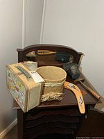 overall lot with lunchbox, camera, boomerangs, woven container on small dresser