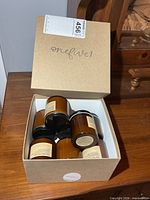 Open box displaying multiple amber glass jar candles