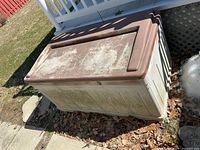 Front angled view of entire Suncast resin deck box showing size and weathering