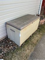 Front angled view of entire deck box beside house