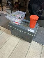 Stacked tackle box, clear plastic tackle bin on top, red canister shown